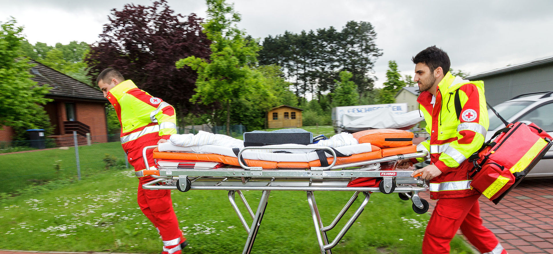 Auf dem Bild sind zwei Mitarbeiter des Krankentransportes zu sehen.
