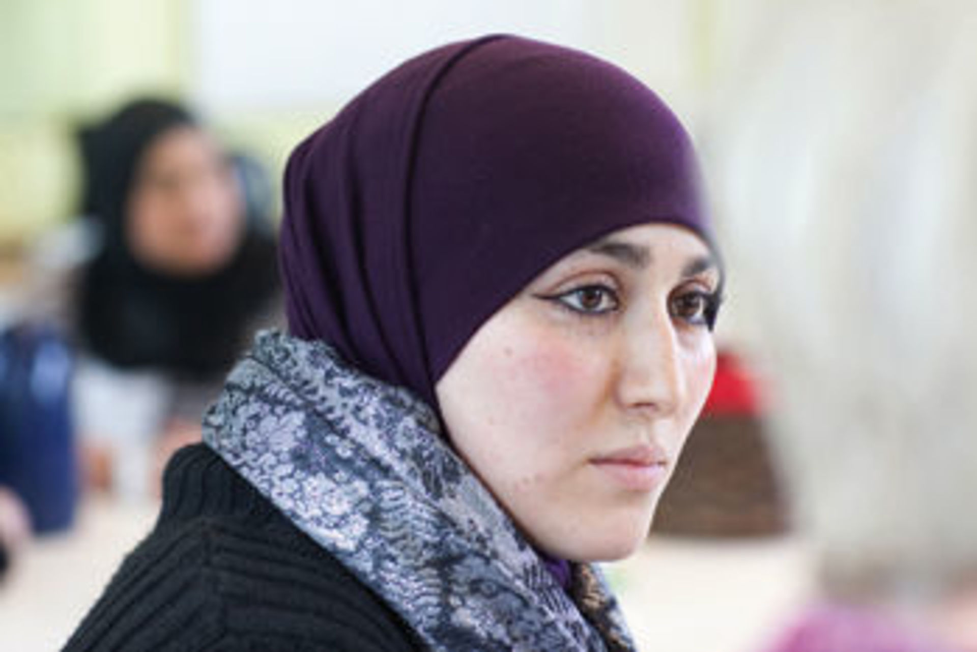 Auf dem Bild ist eine Frau mit Kopftuch zu sehen.