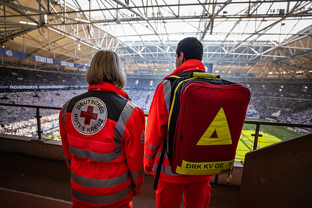 Zwei ehrenamtliche Einsatzkräfte leisten Sanitätsdienst bei einem Fußballspiel