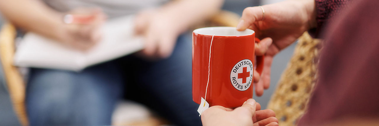 Auf dem Bild ist ein roter Becher mit DRK-Logo zu sehen