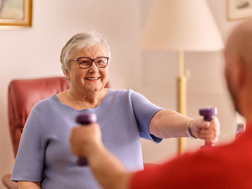 Seniorin trainiert mit Bewegungscoach