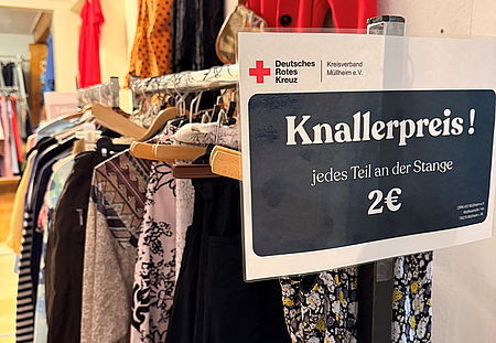 auf dem Bild ist eine Stange mit reduzierten Kleidern zu sehen