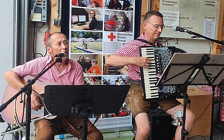 Auf dem Bild sind zwei spielende Musiker mit ihren Instrumenten zu sehen.