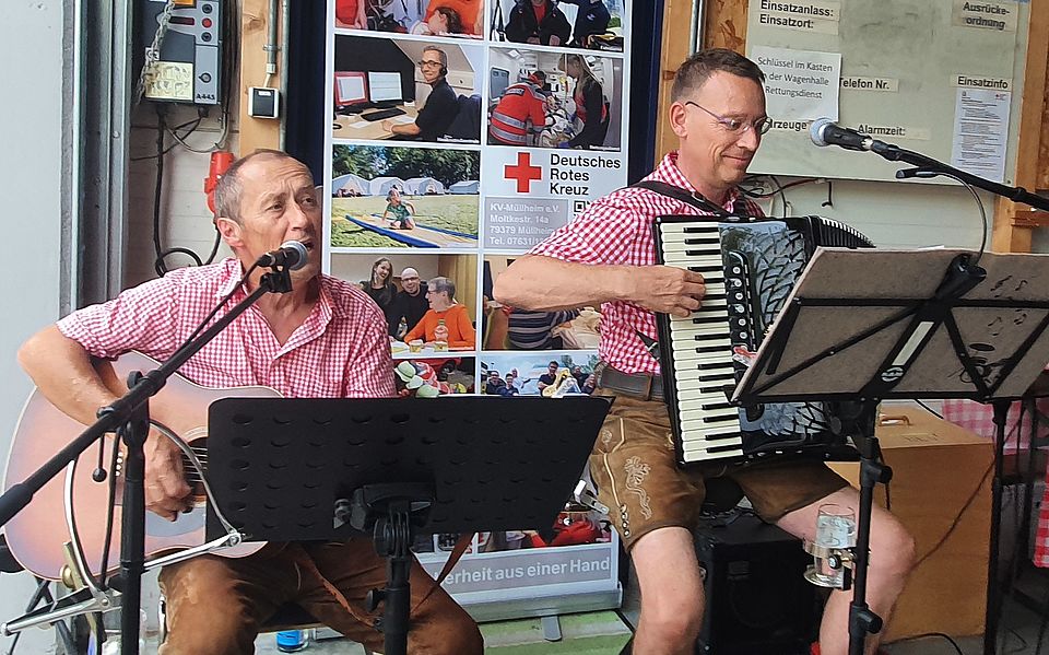 Auf dem Bild sind zwei spielende Musiker mit ihren Instrumenten zu sehen.